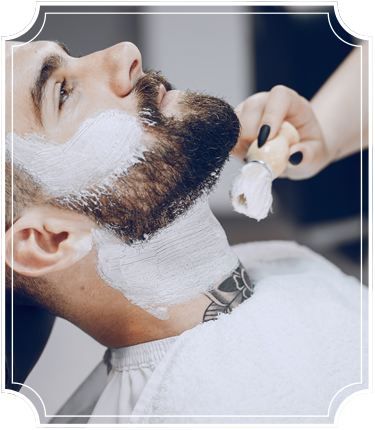 Man in barbershop getting his face shaved with straight razor